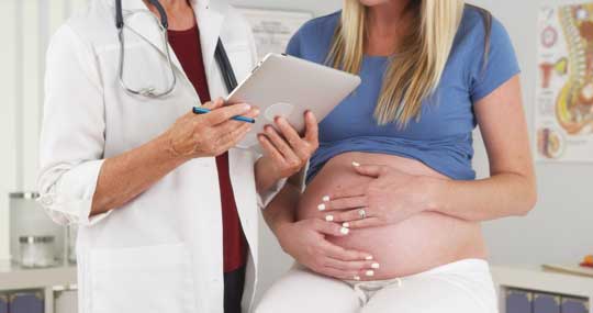 Pregnant woman and doctor in office